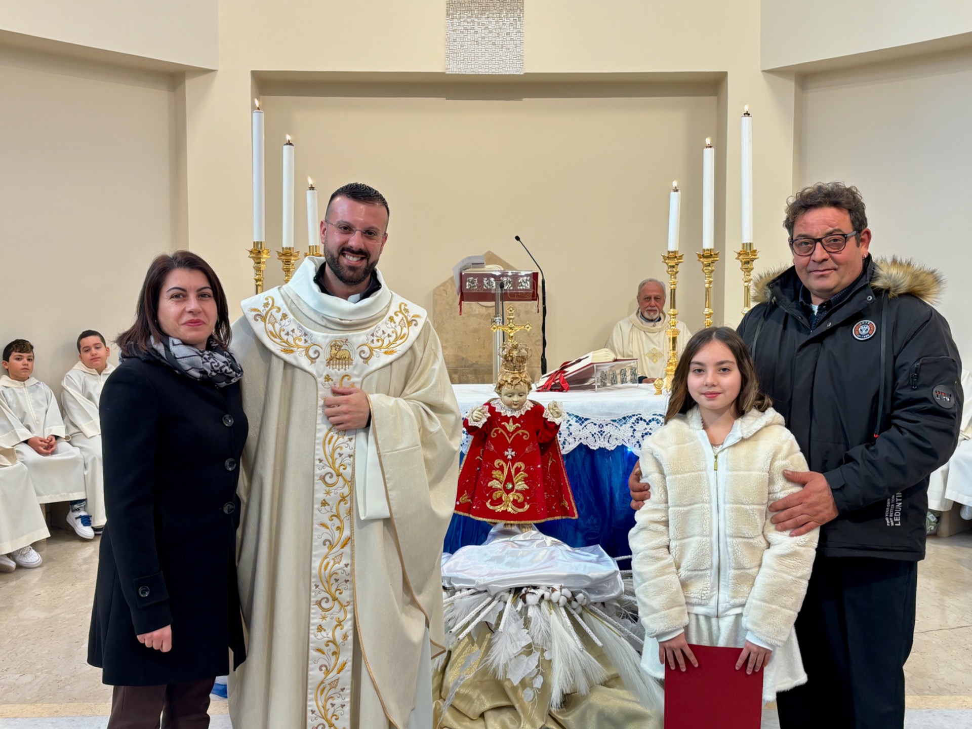 Nella foto: Eleonora Gatto con la famiglia, il Bambinello e don Nicola Mobilio.
